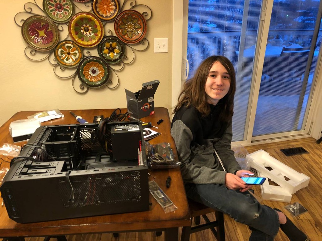 The author at twelve, smiling at a dining table covered with PC parts while building his first computer